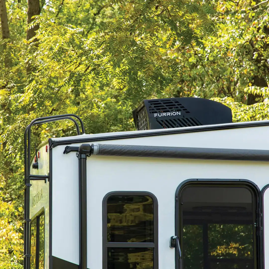 Black furion rooftop air conditioner unit mounted on a white rv.